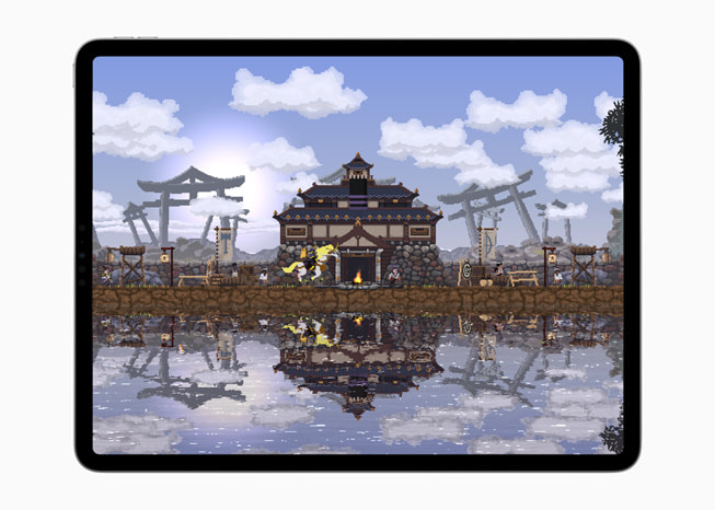 iPad Pro에서 보여주는 Kingdom Two Crowns 게임 속 물 옆에 자리 잡은 주택의 모습을 담은 스틸컷.