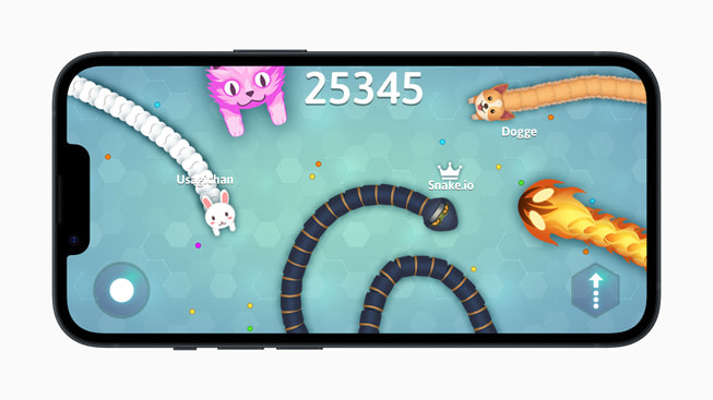 En un iPhone 14, se muestra una imagen del juego Snake.io+ con una serpiente, un gato, un perro, un conejo y un monstruo de fuego.