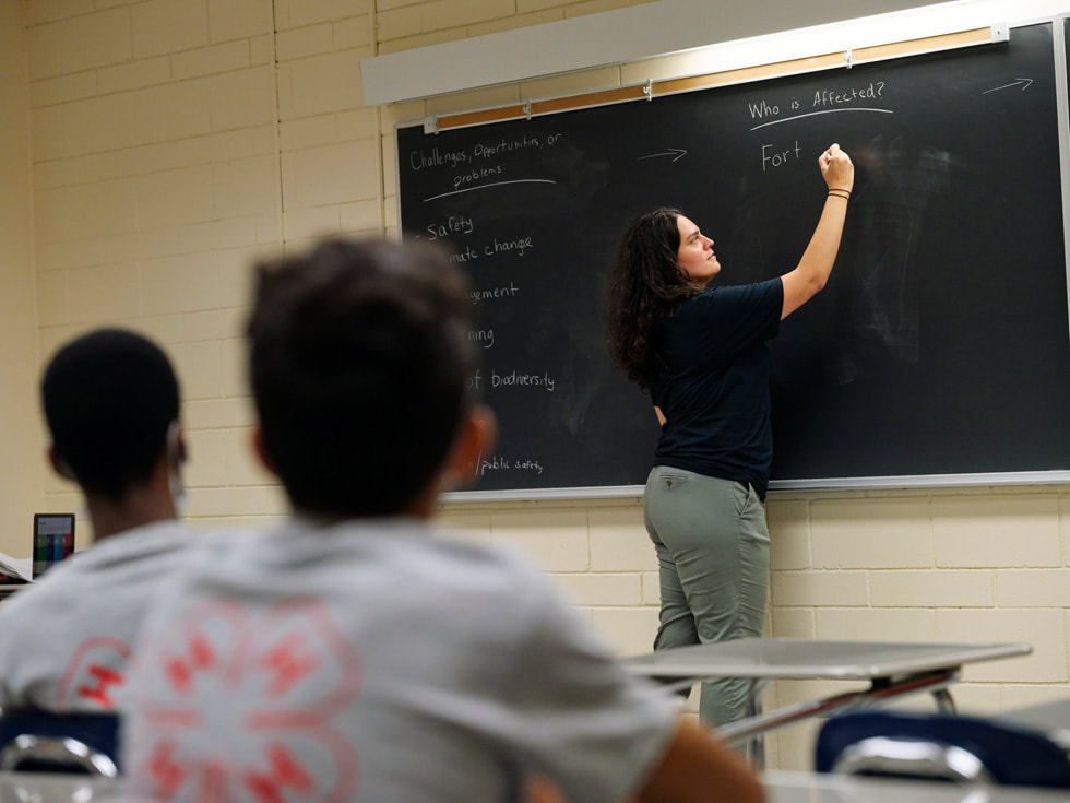 Instrutora do programa Rutgers 4-H Computers Pathways escreve em um quadro negro.