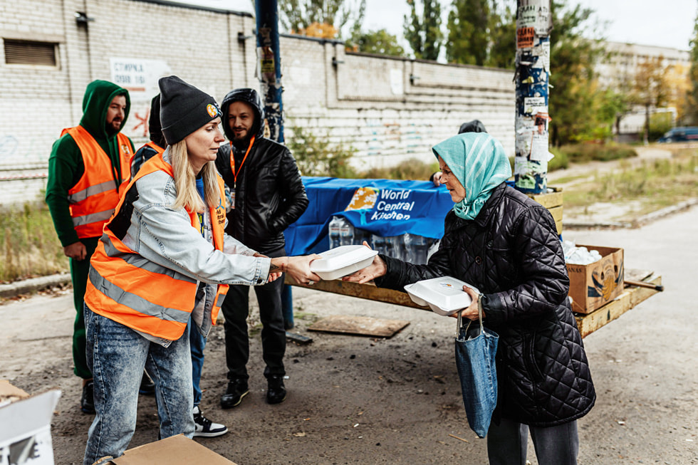 An Apple team member hands out food while volunteering with World Central Kitchen in Ukraine.