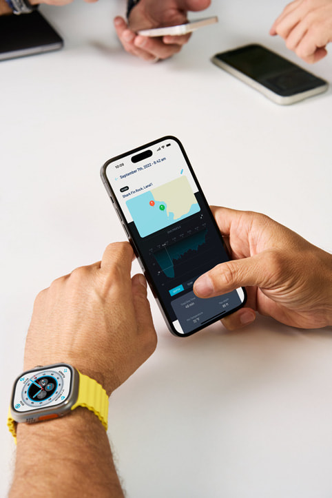 Andrea Silvestri đeo Apple Watch Ultra và nhìn vào ứng dụng Oceanic+ đồng hành trên iPhone.