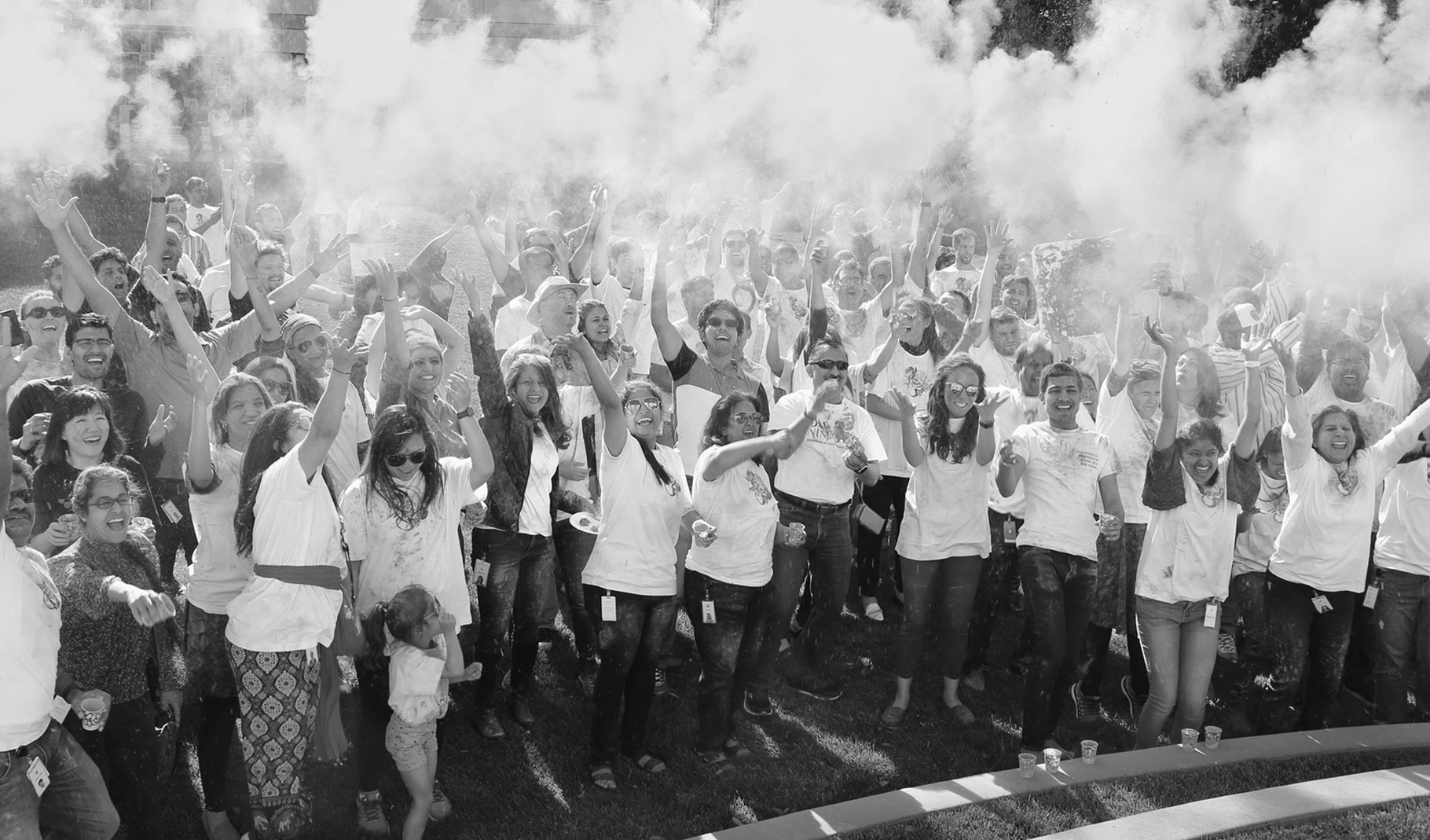 Bilde av en stor gruppe mennesker som roper begeistret utendørs på en Apple-campus.