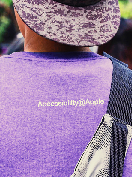 Bilde bakfra av en person som har på seg en T-skjorte med påskriften «Accessibility@Apple».