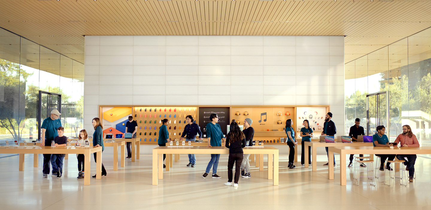 Imagen de un Apple Store con empleados de pie en varios puntos.
