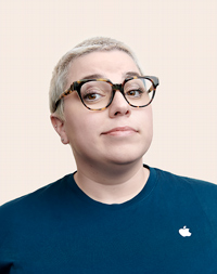 短发 Apple 零售员工戴着眼镜，看向镜头