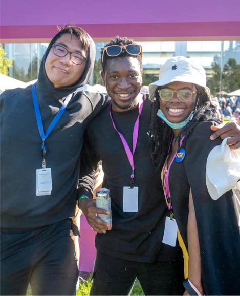 Zdjęcie trojga stażystów Apple, którzy obejmują się ramionami i uśmiechają do aparatu