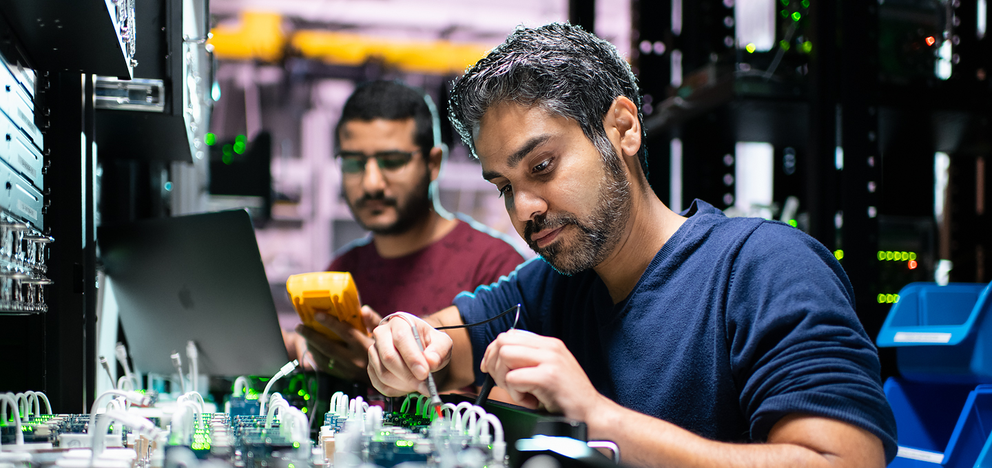 Två av Apples ingenjörer arbetar med iPhone-komponenter i ett labb