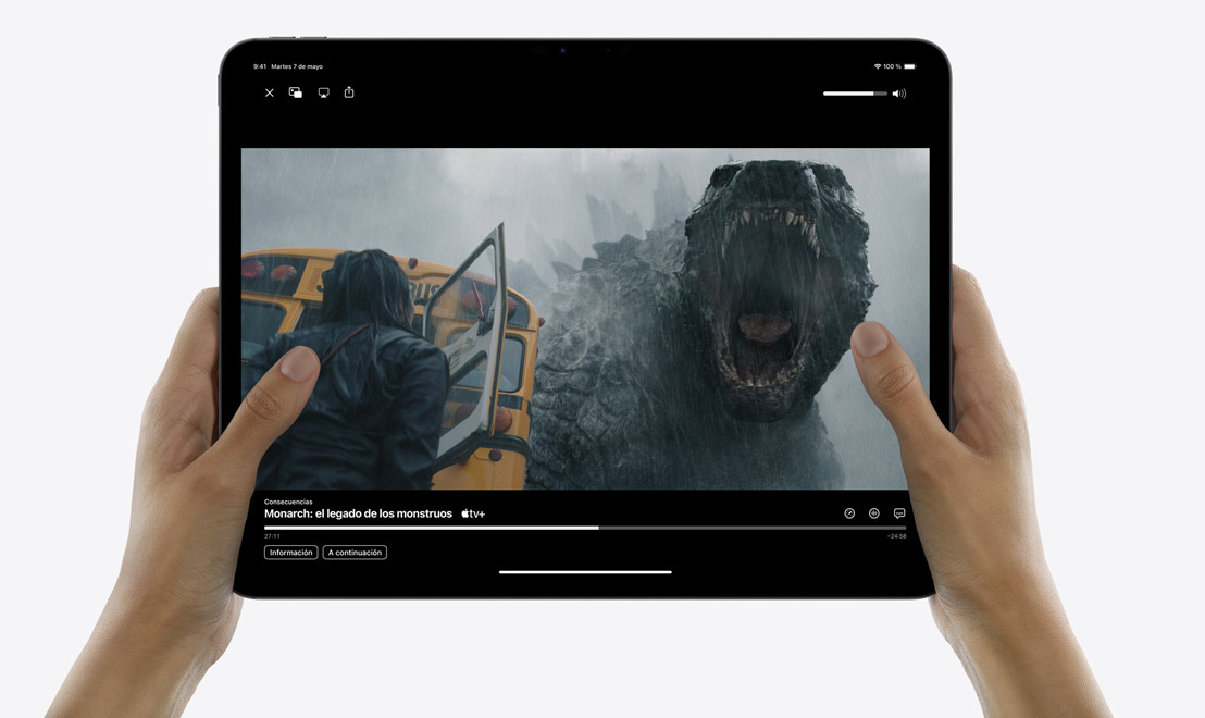 Unas manos sujetan un iPad Pro con la app Apple TV abierta en la que se está reproduciendo la serie «Monarch: El Legado de los Monstruos».