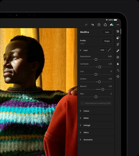 Un iPad Pro, il display mostra che l’utente sta ritoccando la foto di una persona che indossa un maglione colorato