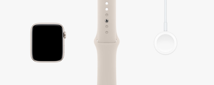 Alineados en fila: Vista frontal de un Apple Watch SE, una correa deportiva en blanco estrella y un cable de carga magnética con conector USB‑C.