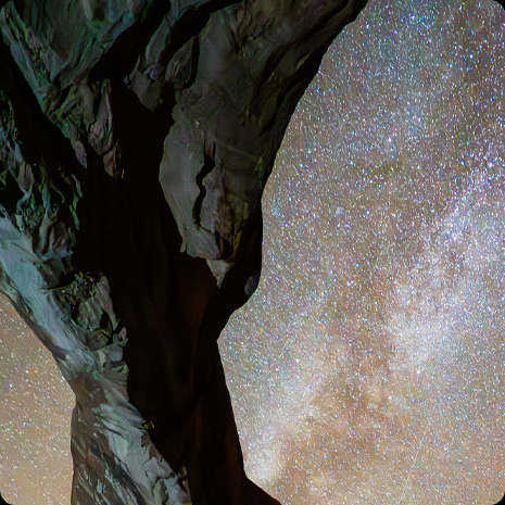 Fotó egy sziklaképződményről, a háttérben csillagos éjszakai égbolttal