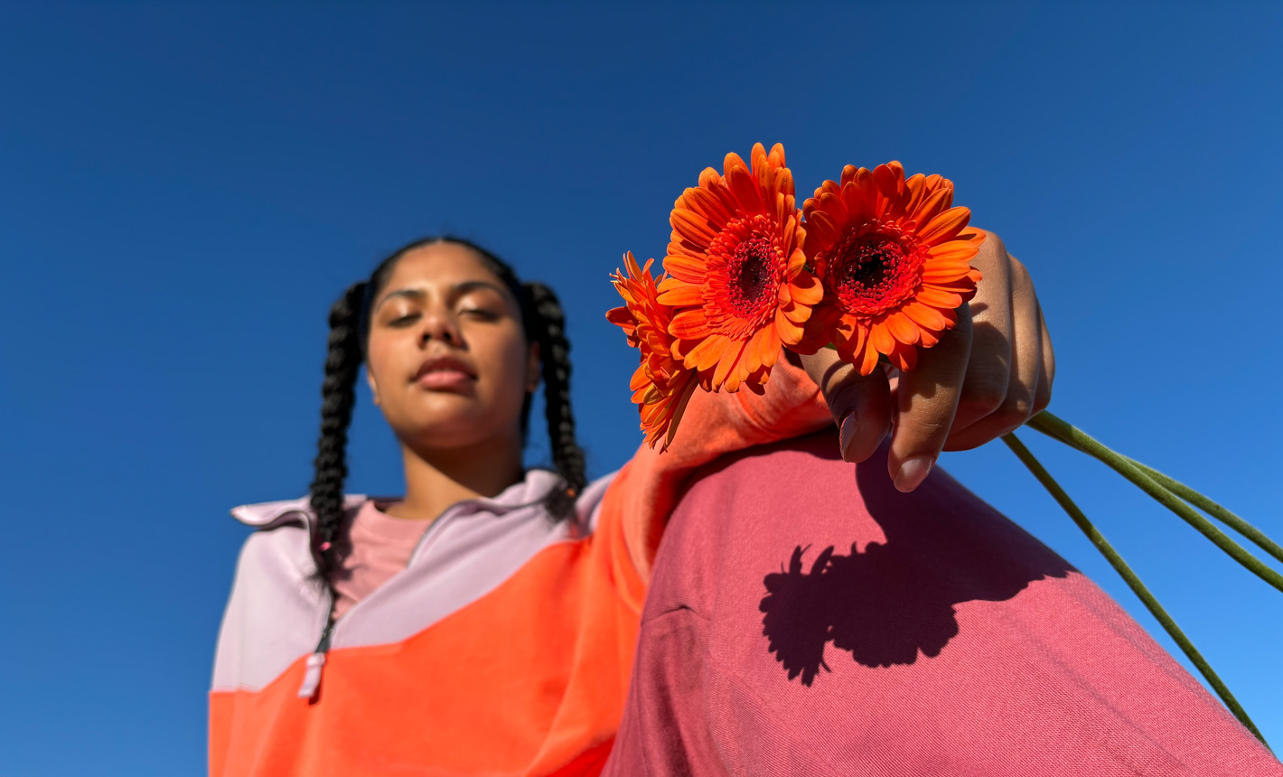 Portréfotó egy virágokat kezében tartó nőről