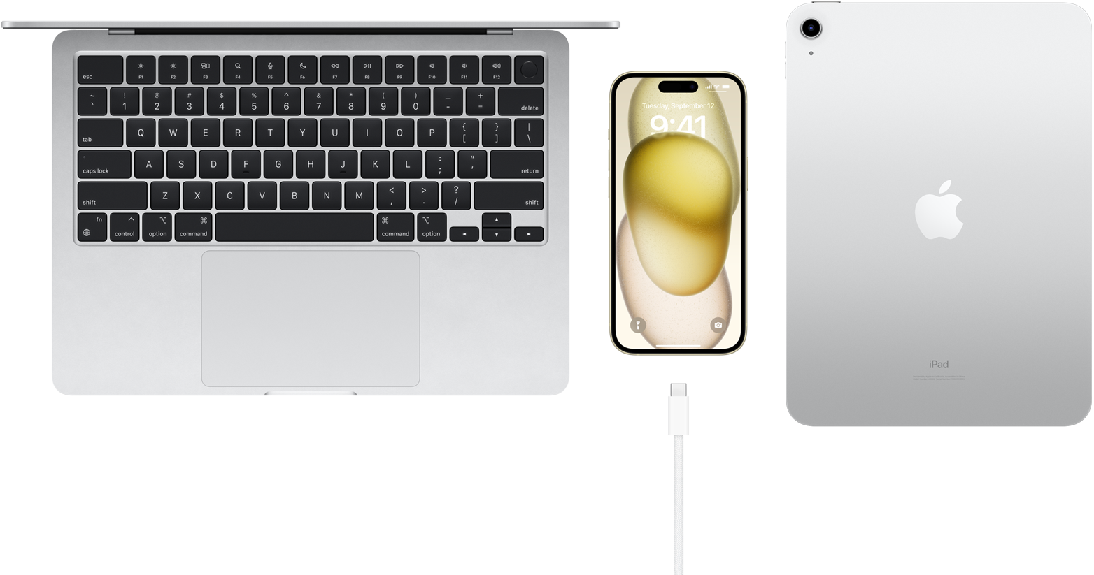 En MacBook Pro, en iPhone 15 med USB-C-port, og en iPad vist ovenfra.