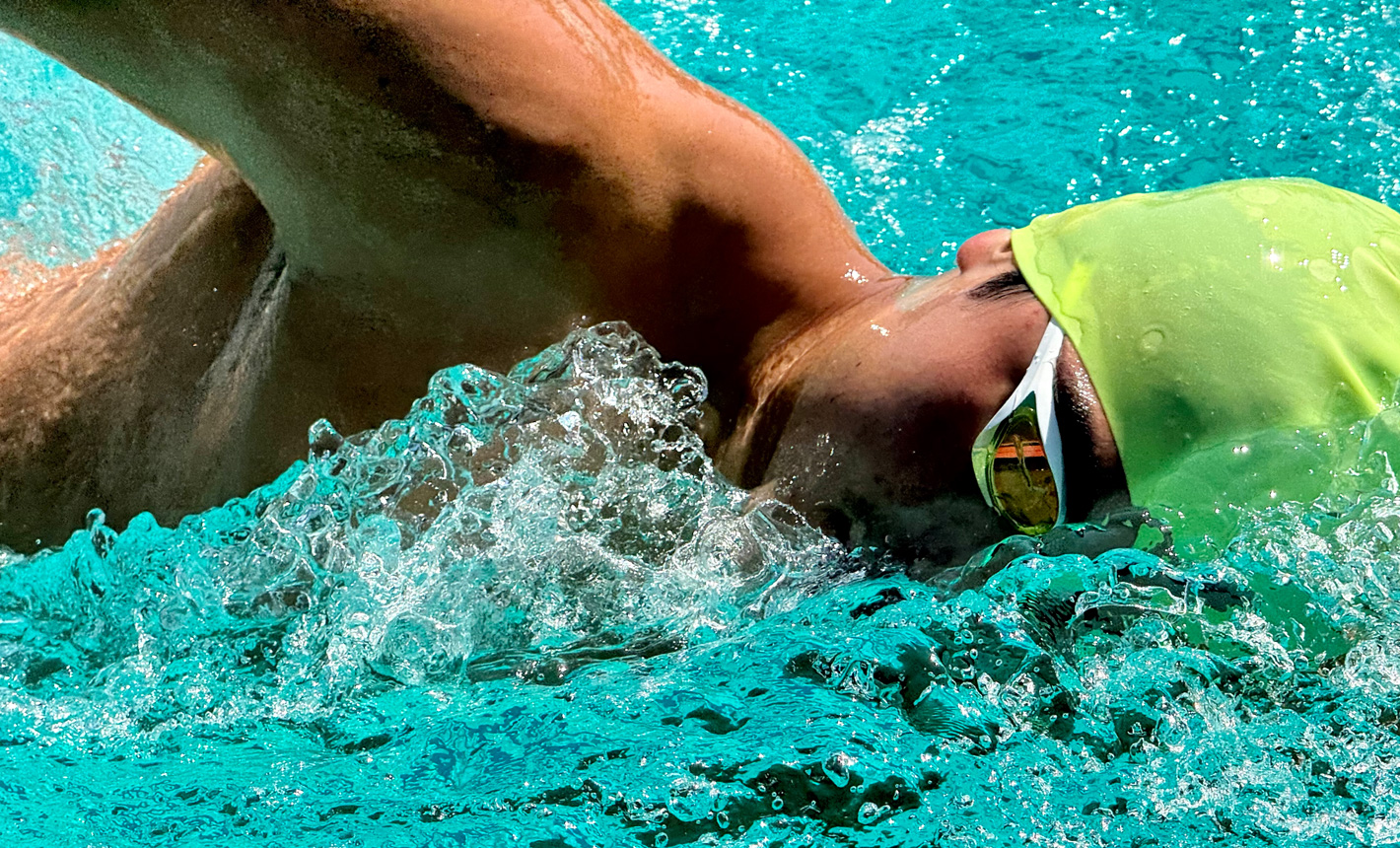 Μια πολύ λεπτομερής ζουμαρισμένη λήψη ενός κολυμβητή σε μια πισίνα, με το νερό να πιτσιλάει γύρω του