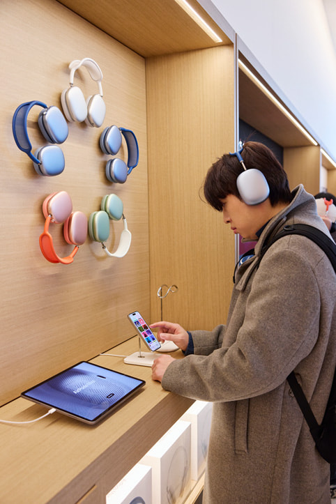 一位顾客正在试戴 AirPods Max 系列耳机。