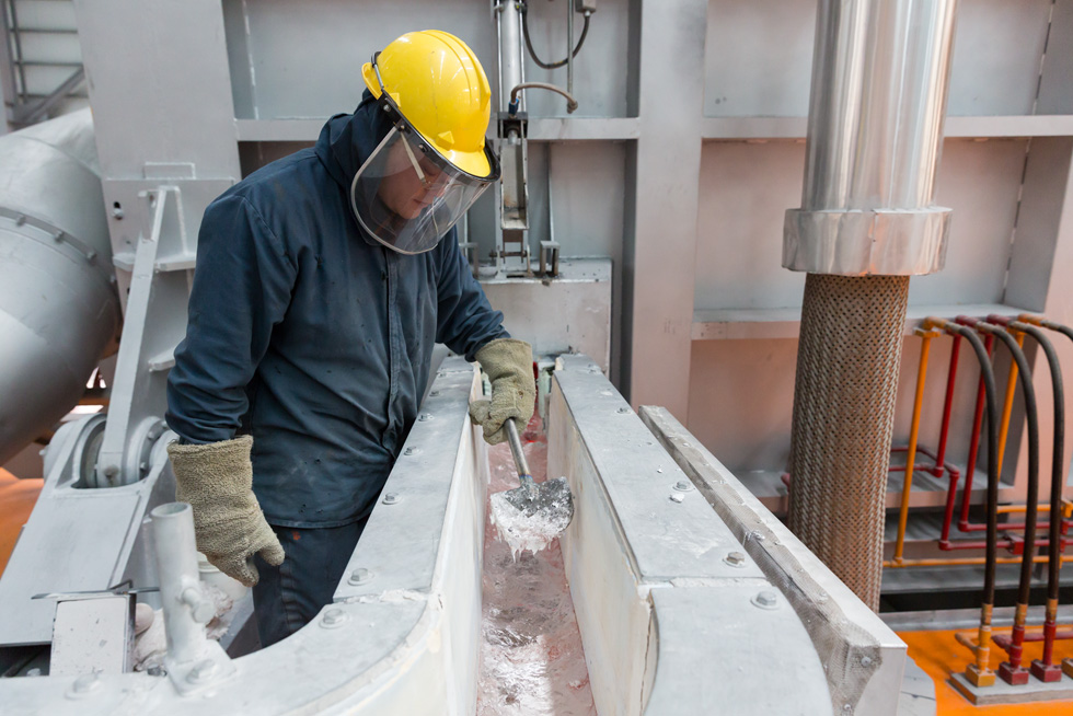 一家制铝厂的一名工人在监视冶炼过程。