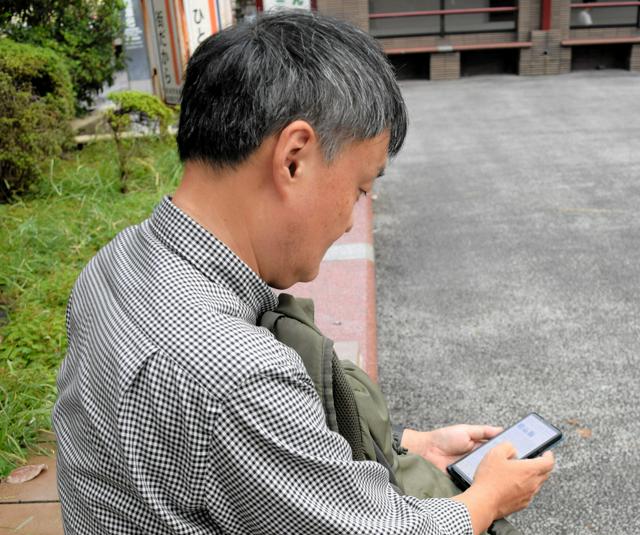 休日、自宅近くの公園でくつろぐ56歳男性。休日はだれとも話さないこともあるという＝東京都内