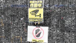 黒い幕に付けられた注意書き。英語で「触るな」と書かれている=2024年5月30日、山梨県富士河口湖町、池田拓哉撮影