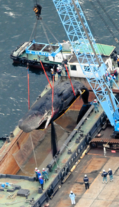 クレーンで船に積まれるクジラ＝２０２３年１月１８日午後、大阪市此花区、朝日新聞社ヘリから、小川智撮影
