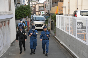 現場から離れる捜査員らと警察車両=2024年5月23日午後6時23分、東京都品川区、小宮健撮影