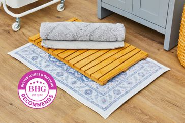 three bath mats piled on top of one another on a wood floor