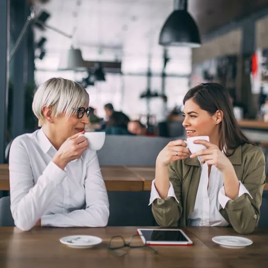 two women having a conversation over coffee