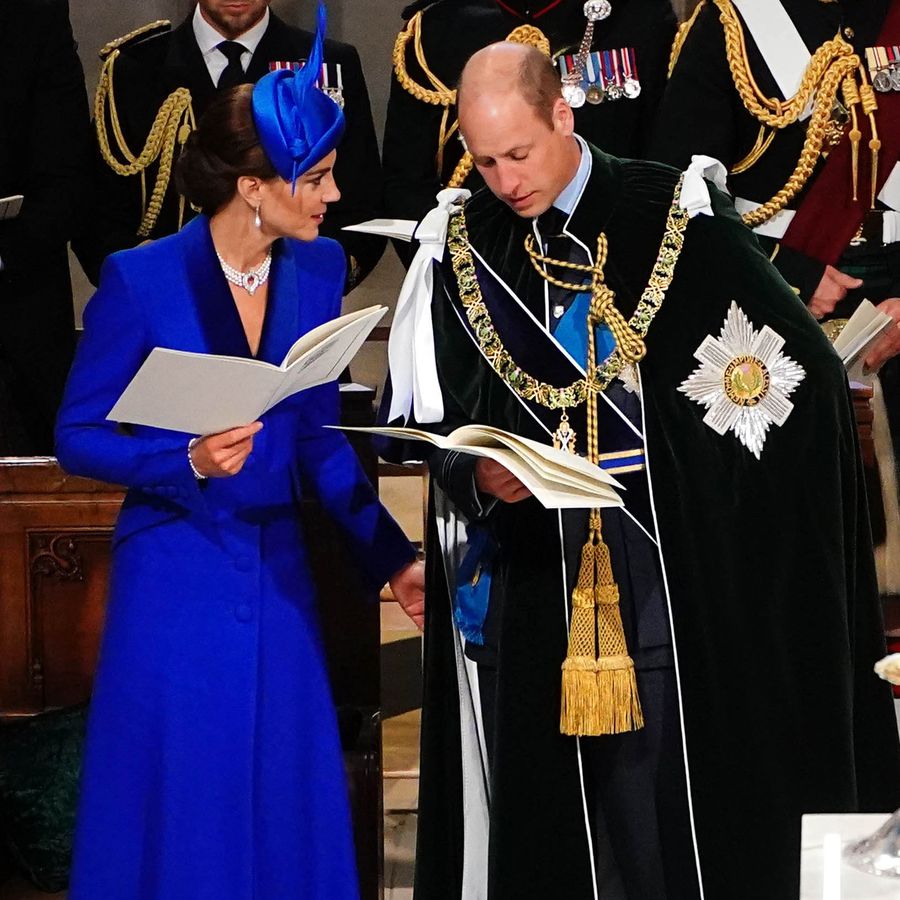 Kate Middleton talking to Prince William while theyâre both holding hymnals at the Scottish coronation for King Charles III