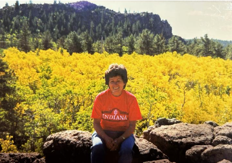 Photograph of Dr. Bernal wearing a red shirt sitting in nature.