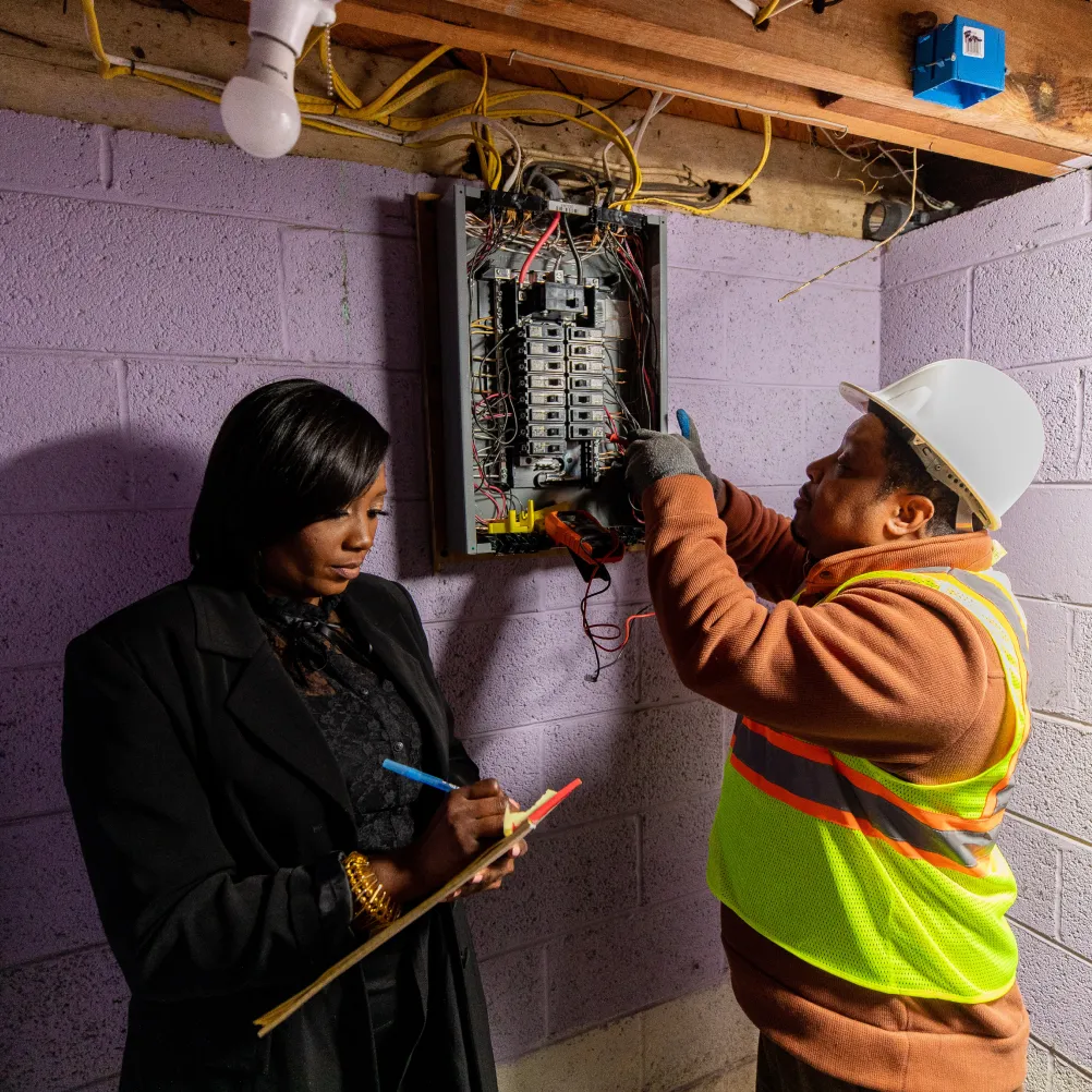 Photo showing an electrician working on a fuse box