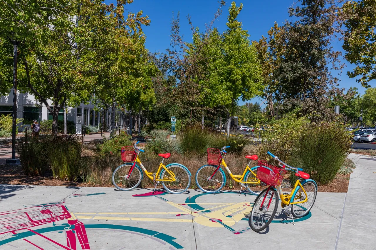 Three Google bikes sit outside of a buidling