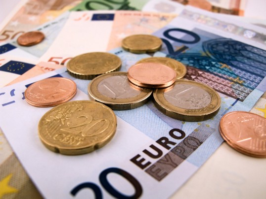 20 Euro-Schein mit darauf liegenden Euro-Münzen