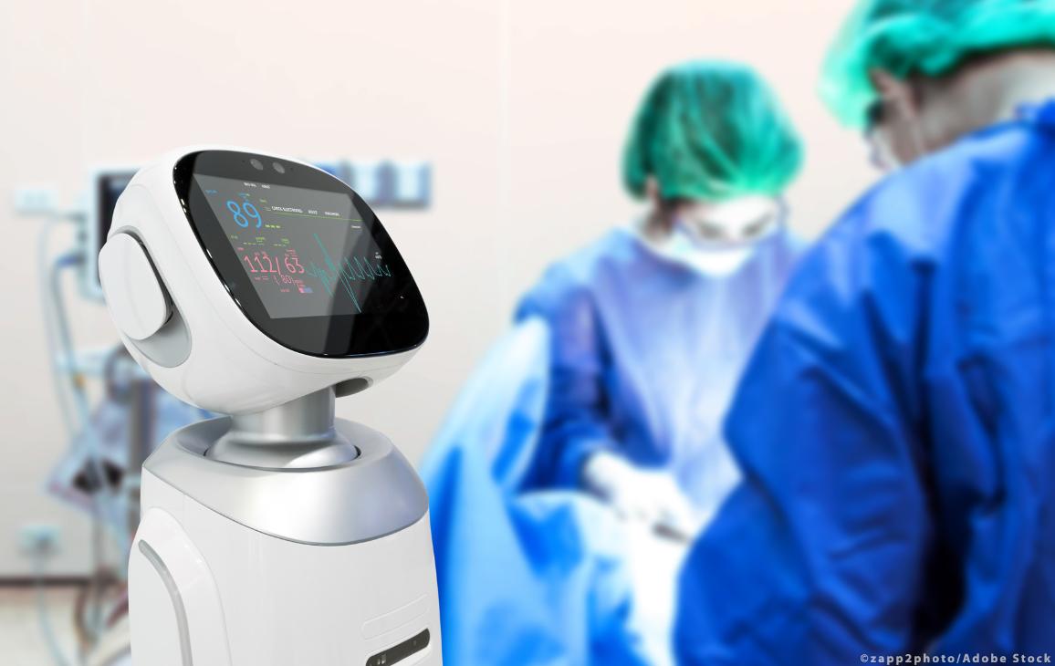 Des chirurgiens opèrent alors qu'un robot affiche l'état du patient © AdobeStock/zapp2photo