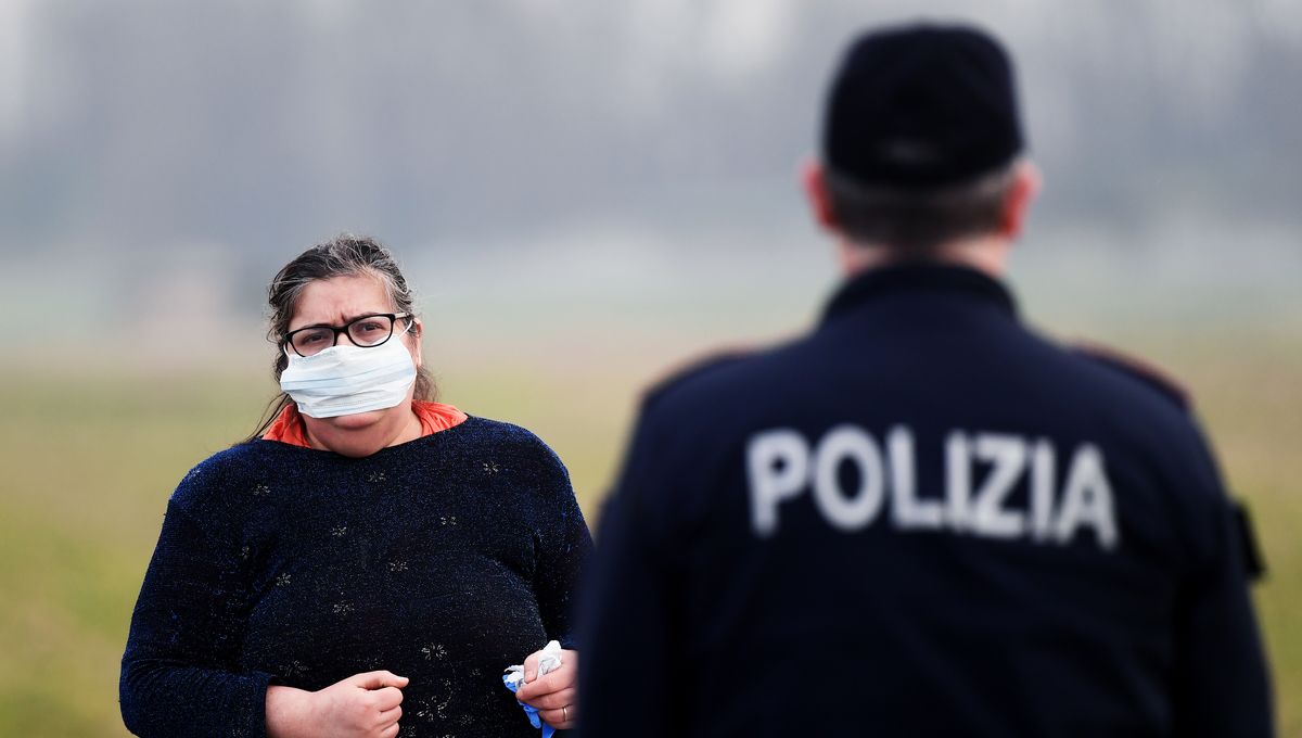 Une résidente portant un masque demande des informations à un policier près de Milan (photo d'illustration).