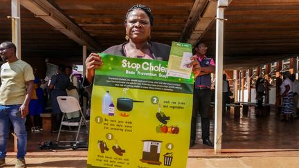 En pleine campagne de vaccination au Zimbabwe, l'un des pays les plus touchés par l'épidémie, une femme brandit des conseils pour se prémunir du choléra. (NYASHA MUKAPIKO / MAXPPP)