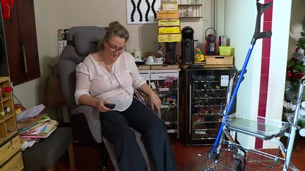 Anabela Neto dans son salon. Cette femme de 54 ans passe du fauteuil roulant au déhambulateur, elle ne peut plus marcher normalement, n'a plus de vie de famille et d'emploi. Handicapée à vie depuis la pose d'une bandelette urinaire en 2021, elle ne ménage pas ses efforts pour faire avancer sa cause. (France 3 Pau Sud-Aquitaine)
