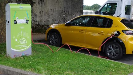 Une voiture électrique en charge sur le parking d'une station-service (MATHIEU THOMASSET / HANS LUCAS)
