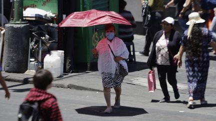 Une dame s'abritant de la chaleur dans les rues de Mexico (Mexique), le 16 avril 2024. (GERARDO VIEYRA / AFP)