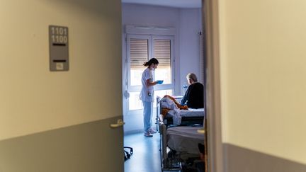 Une infirmière s'assure de l'hydratation d'une pensionnaire d'un hôpital à Bry-sur-Marne (Val-de-Marne), le 23 juin 2023. (ALINE MORCILLO / HANS LUCAS / AFP)