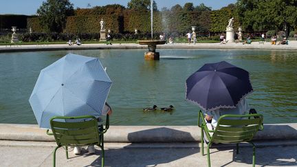 Des personnes se protègent de la chaleur à Paris, le 10 septembre 2023 (VALERY HACHE / AFP)