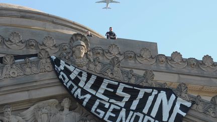 Un officier de la police de New York se tient, vendredi 31 mai, sur le toit du musée de Brooklyn où des manifestants propalestiniens ont déposé une banderole dans le cadre d'une manifestation, à New York, pour dénoncer les opérations militaires israéliennes à Gaza. (SOPA IMAGES/SIPA / SIPA)
