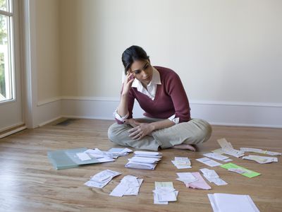 Woman looking at bills on the floor.
