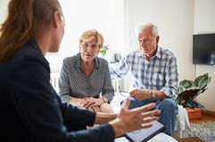 elderly couple meeting a financial advisor at home