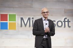 Microsoft CEO Satya Nadella in front of the company's logo. 