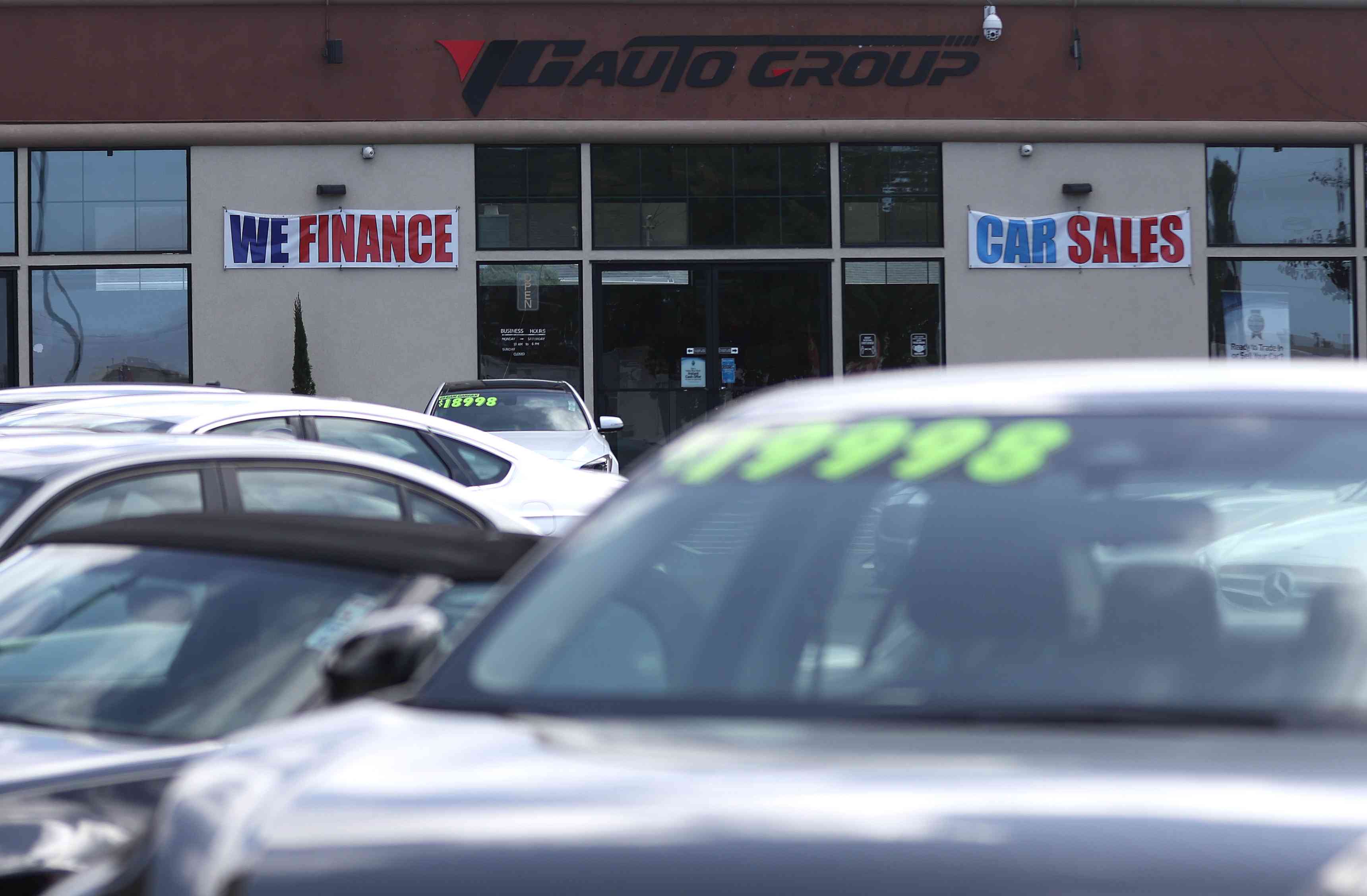 A "We Finance" sign is posted at an auto dealership in California. 