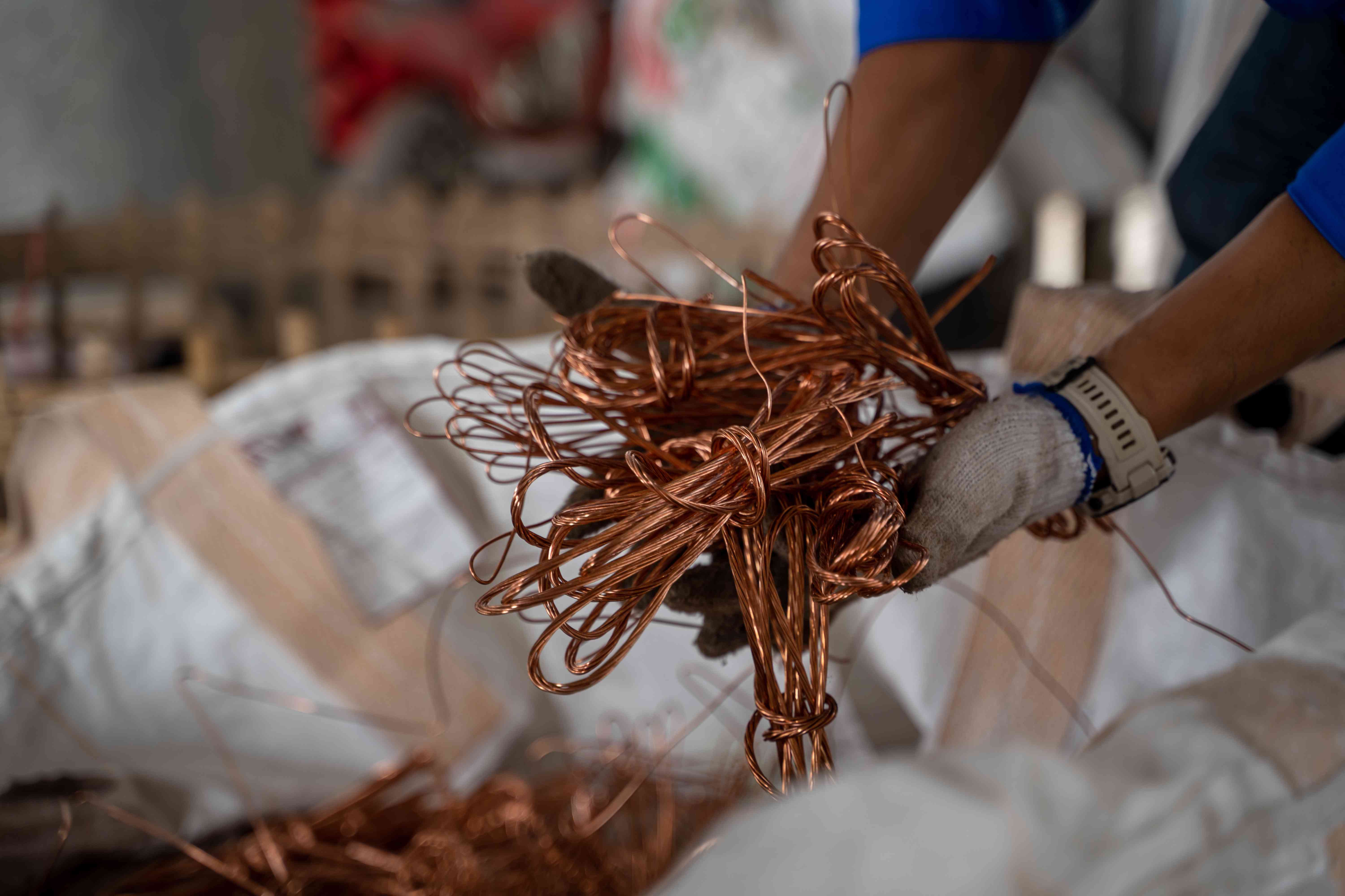 Worker holding copper wire in a factory