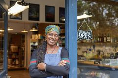 Portrait of Black female shop owner in shop door way