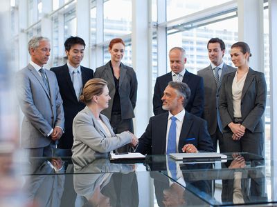Business People Shaking Hands in Conference Room