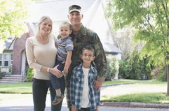 Military family in front of house