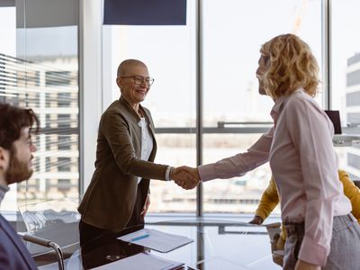 Business woman shaking hands with another professional