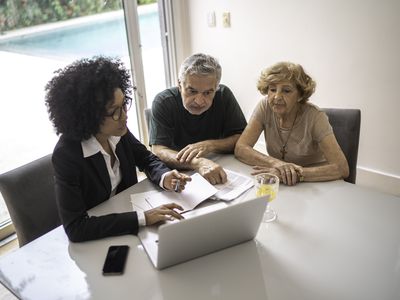 A financial advisor helping a senior couple at home.